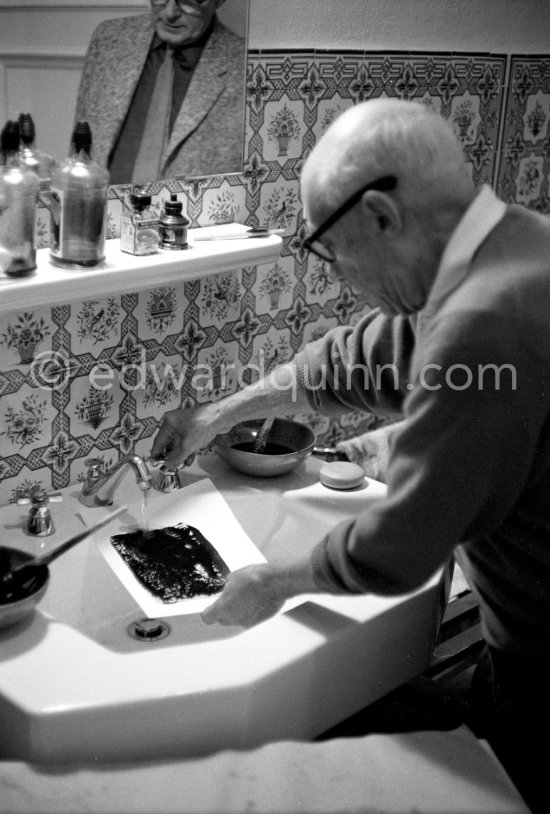 Pablo Picasso washing a linocut print to remove surplus ink. Even though he was nearly eighty at the time he did this work, he enjoyed the physical effort and the adventure. Roland Penrose in the mirror. Mas Notre-Dame-de-Vie, Mougins 1964. - Photo by Edward Quinn