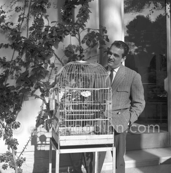 Rainier, Prince of Monaco and a parrot in front of the Villa Iberia in Saint-Jean-Cap-Ferrat 1954. At this compound, he kept numerous animals and had his private workshop and photo lab built. - Photo by Edward Quinn