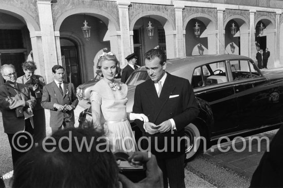 Prince Rainier and Princess Grace meeting Monegasque people in the courtyard of the Royal Palace. Monaco 1956 for the official reception of the wedding presents. Grace Kelly wore a pale blue chiffon day dress by the California designer James Galanos. She accessorized z^the dress with a small headpiece of matching blue ribbon, white gloves and the same Morabito needlepoint bag she had carried to the Academy Award of 1955. Rolls Royce Silver Cloud I, Standard Steel Sports Saloon, was a wedding-gift by the Conseil Nationale de Monaco to their Souvereign to celebrate the marriage. When the car was ordered the specifications included that Crown and Cypher were to be applied to the front doors – thus giving off this was an owner-driver car (cars exclusively chauffeur-driven showed the Armorial Bearings on their rear doors). Indeed The Prince and his wife, too, are known to have driven this car frequently. His Serene Highness’ driving attitude (speedy – to put it mildly) on a later visit to Rome in 1957 did surprise the escorting Carabinieri on their motor-bikes; such they had neither expected from this motor car nor from the Souvereign of the Principality. All of the prince\'s cars had license plates ending in 77. Monaco 1956. - Photo by Edward Quinn