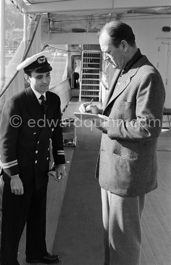 John Wayne signing autographs on board Aristotle Onassis\' luxurious yacht Christina. Monaco harbor 1955. - Photo by Edward Quinn