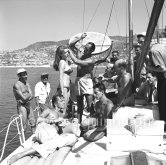 Brigitte Bardot during filming of “Manina, la fille sans voiles”.  With Film director Willy Rozier and British actor Howard Vernon. Villefranche harbor 1952. - Photo by Edward Quinn