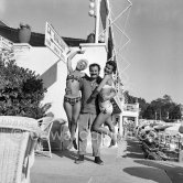 At the beach, two amateur pin-ups are proud to be photographed with the well-known French singer Georges Brassens. Juan-les-Pins 1953. - Photo by Edward Quinn