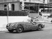 Clark Gable and “fiancée” Suzanne Dadolle, French model, in front of Hotel Bleu Rivage. Cannes 1953. 1951 Jaguar XK120 OTS Battleship grey/red. Car today see https://bit.ly/3kLirWW - Photo by Edward Quinn