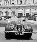 Clark Gable and "fiancée" Suzanne Dadolle, French model, in front of Carlton Hotel. Cannes 1953. Car: 1951 Jaguar XK120 OTS Battleship grey/red, Car today see https://bit.ly/3kLirWW - Photo by Edward Quinn