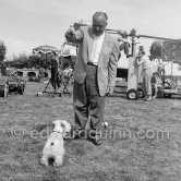 A moment of relaxation for Alfred Hitchcock. In between shots on his film "To Catch A Thief" he tries to get his terrier to play. Hitchcock adored Sealyham Terriers. Two of them, Geoffrey and Stanley, made a cameo appearance in the movie "The Birds". Cannes 1954. - Photo by Edward Quinn