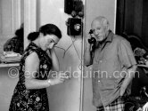 Pablo Picasso and Jacqueline at the telephone. She is wearing a dress with printed motifs of a Pablo Picasso work. La Californie, Cannes 1956. - Photo by Edward Quinn