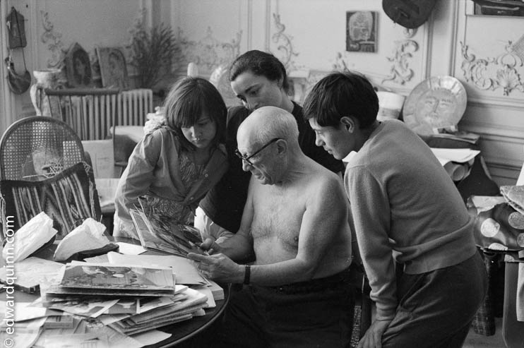 Pablo Picasso, Jacqueline, Claude and Paloma viewing photos by Quinn. La Californie, Cannes 1960.