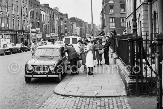 Family with her newborn baby in front of the Maternity Hospital. Dublin 1963. Car: Renault 4 - Photo by Edward Quinn
