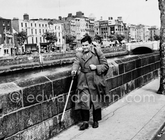 Along the Liffey side with O\'Connell Bridge in the background. Dublin 1963. Published in Quinn, Edward. James Joyces Dublin. Secker & Warburg, London 1974. - Photo by Edward Quinn