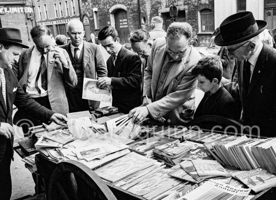 Men browsing at a secondhand bookstall at Bachelors\' walk Dublin 1963. Published in Quinn, Edward. James Joyces Dublin. Secker & Warburg, London 1974. - Photo by Edward Quinn