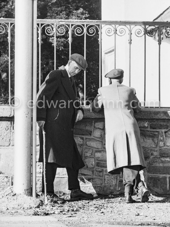 Two Dubliners chat outside the gate of Phoenix Park near Islandbridge. Dublin 1963. Published in Quinn, Edward. James Joyces Dublin. Secker & Warburg, London 1974. - Photo by Edward Quinn