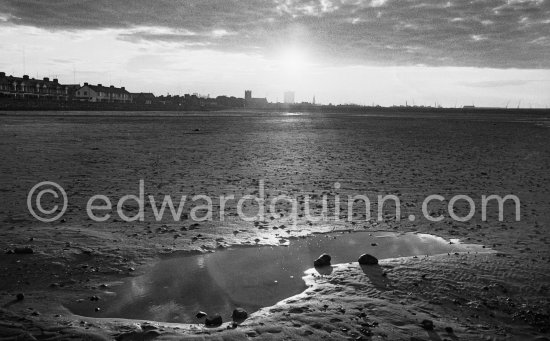 The Sandymount Strand with Leahy's Terrace and lrishtown. Dublin 1963. Published in Quinn, Edward. James Joyces Dublin. Secker & Warburg, London 1974. - Photo by Edward Quinn