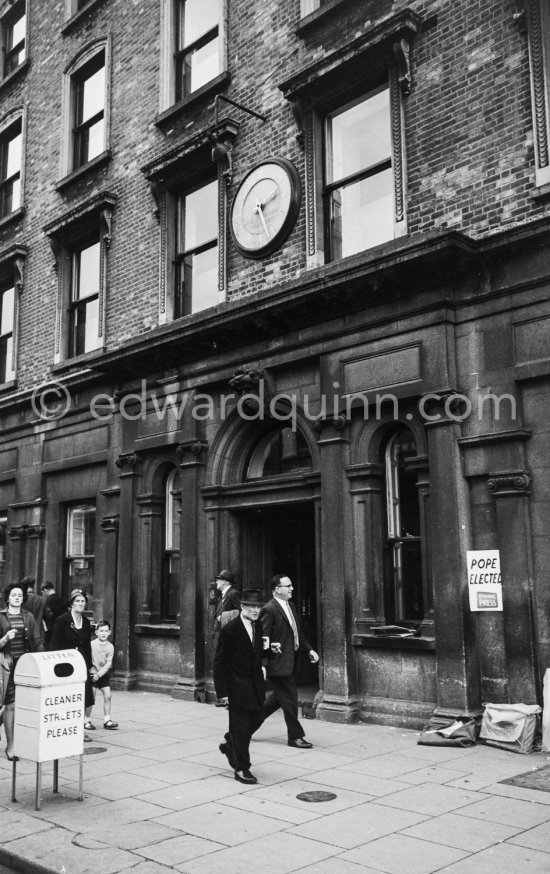 The Ballast Office Clock at Westmoreland Street. Dublin 1963. Published in Quinn, Edward. James Joyces Dublin. Secker & Warburg, London 1974. - Photo by Edward Quinn