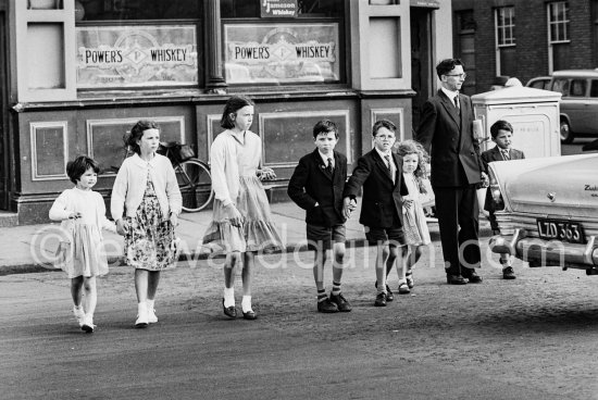 Large family in front of O\'Meara\'s Irish House, corner of Winetavern Street and Wood Quay. Dublin 1963. - Photo by Edward Quinn