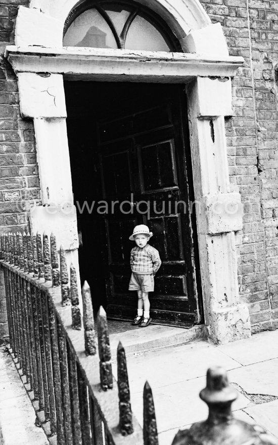 A little boy in front of 7 Eccles Street, Mr. Bloom\'s residence (Joyce, Ulysses). Dublin 1963. Published in Quinn, Edward. James Joyces Dublin. Secker & Warburg, London 1974. - Photo by Edward Quinn