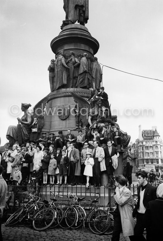 Waiting for President Kennedy to drive past during his visit. O\'Connell Monument, Bachelor\'s Walk / O\'Connell Street. Dublin 1963. - Photo by Edward Quinn