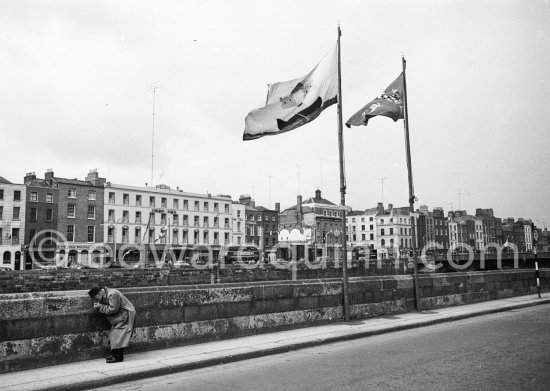 Essex Quay. A man lights a cigarette. Opposite the hotel  Ormond, Upper Ormond Quay. Featured "the Sirens" chapter in James Joyce’s Ulysees. Dublin 1963. - Photo by Edward Quinn