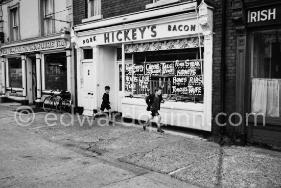 Boys running past Hickey\'s butcher. Dublin 1963. - Photo by Edward Quinn