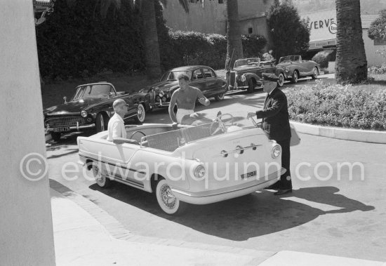 An entry without a door. Gianni Agnelli in swimming shorts. With a friend near his Riviera home, Monte Carlo 1958. Cars: 1956 Fiat 600 Multipla Torpedo Marina Carrozzeria Boano. Background from right: Sunbeam Talbot drophead (same model, though one pictured is right-hand drive, used by Grace Kelly in Hitchcock\'s "To Catch a Thief"); 1951 Mercedes-Benz 220 Cabriolet A; 1955-58 Jaguar 2.4 Mark 1; 1956-62 Simca Aronde Océane - Photo by Edward Quinn