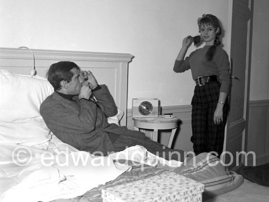 Brigitte Bardot being photographed by her husband Roger Vadim in their room at the Hotel Negresco. With a portable radio. Nice 1955. - Photo by Edward Quinn