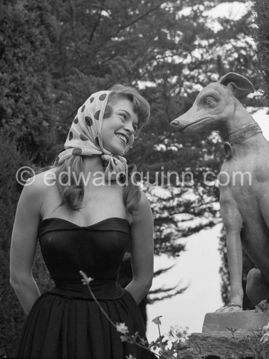 Brigitte Bardot posing with a dog sculpture. Cannes Film Festival 1953. - Photo by Edward Quinn