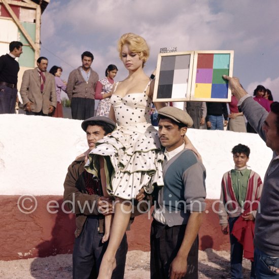 Brigitte Bardot during filming of the last scenes of "Les Bijoutiers du clair de lune" ("The Night Heaven Fell"), on the grounds of the Studios de la Victorine in Nice. Directing the film is Brigitte’s ex-husband Roger Vadim. Brigitte is carried by two Romani. The scene is supposed to represent Brigitte being carried victoriously out of the bull ring, after having given battle to a bull. All people in the back, young and old, are Romani. Nice 1958. - Photo by Edward Quinn