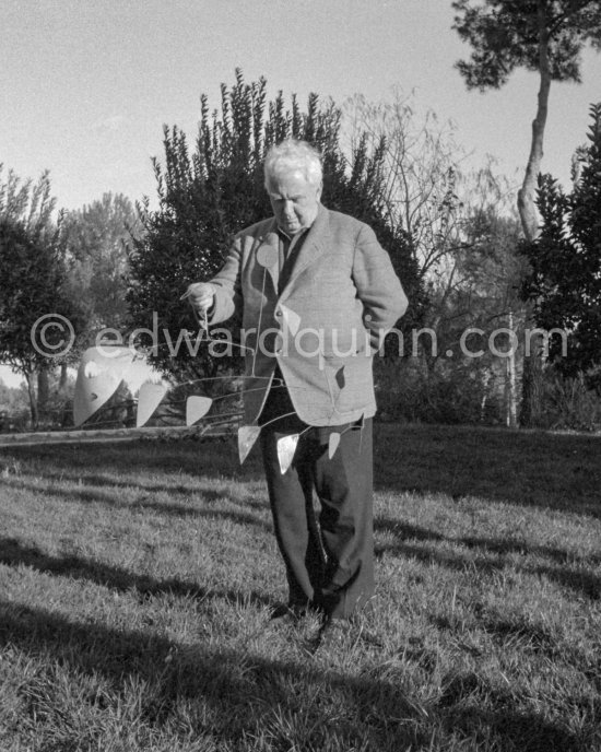 Alexander Calder presents one of his mobiles during a visit to art dealer Aimé Maeght in Saint-Paul-de-Vence 1961. - Photo by Edward Quinn