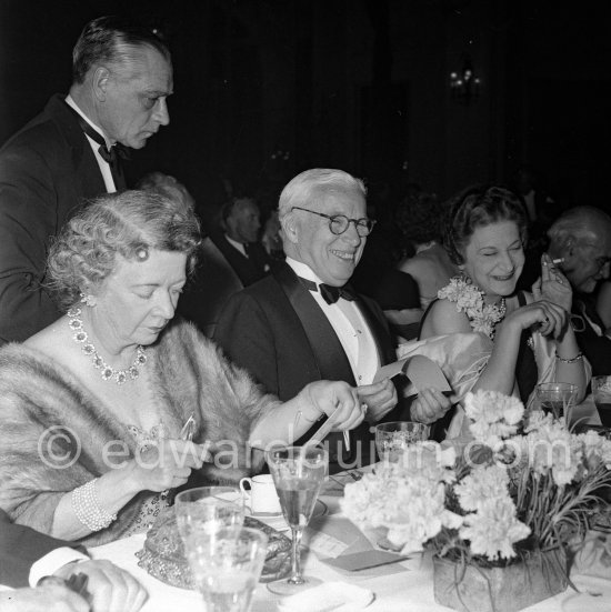 Charlie Chaplin surrounded by friends at the Figaro Gala in Cannes, 1953. - Photo by Edward Quinn