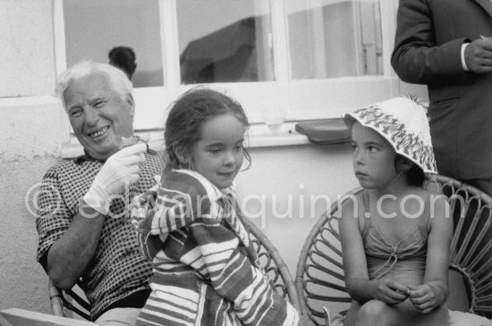 Charlie Chaplin with two of his daughters, Josephine and Victoria (left). Chaplin was in Cannes to talk to the press about his latest film, "A King in New York", due to be premiered in London. When asked why he was wearing white gloves, he said it wasn\'t coquetry, but a slight case of eczema. Villa Lo Scoglietto, Saint-Jean-Cap-Ferrat, 1956. - Photo by Edward Quinn