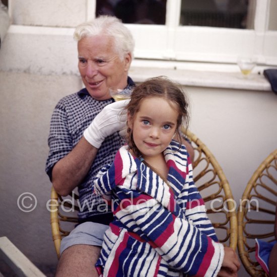 Charlie Chaplin with his daughter Victoria. Chaplin was in Cannes to talk to the press about his latest film, "A King in New York", due to be premiered in London. When asked why he was wearing white gloves, he said it wasn\'t coquetry, but a slight case of eczema. Villa Lo Scoglietto, Saint-Jean-Cap-Ferrat, 1956. - Photo by Edward Quinn