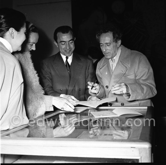 Jean Cocteau in the Galerie des Ponchettes dedicating a catalogue, Nice where there is an exhibition of his paintings. With two Cartier Trinity rings. 10th February 1953. - Photo by Edward Quinn