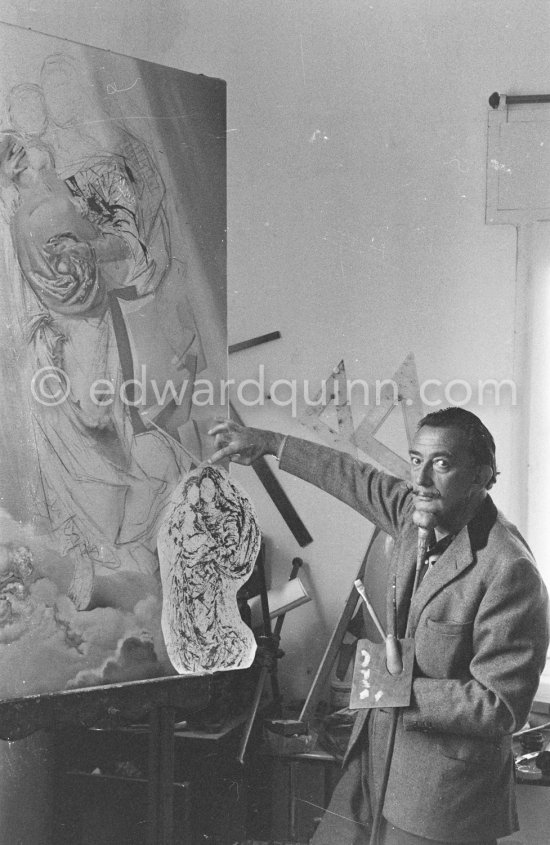 Salvador Dalí poses at his studio with his ink drawing of a madonna and her child and the painting "Cosmic Madonna", finished in 1958. At Salvador Dalí's house, Portlligat, Cadaqués, 1957. - Photo by Edward Quinn
