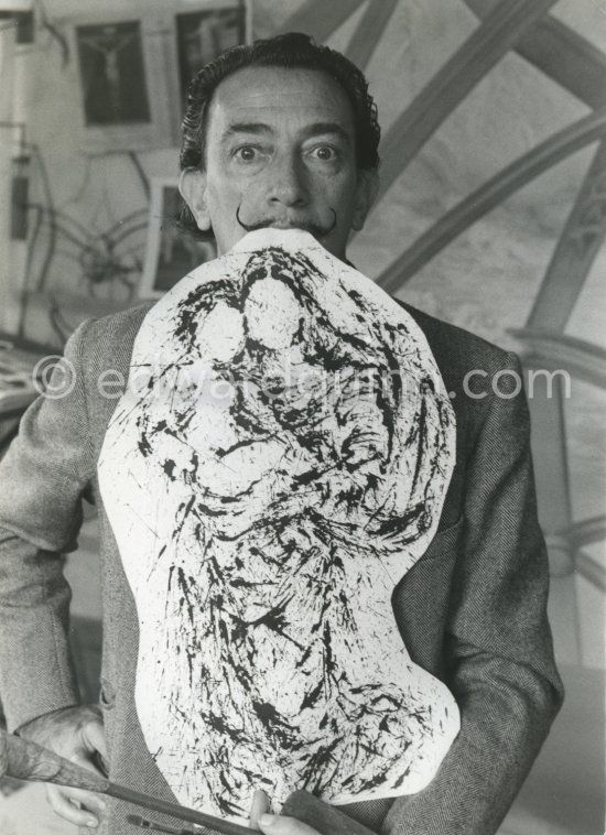 Dalí poses at his studio with his ink drawing of a madonna and her child and the painting "Cosmic Madonna", finished in 1958. At Salvador Dalí\'s house, Portlligat, Cadaqués, 1957. - Photo by Edward Quinn