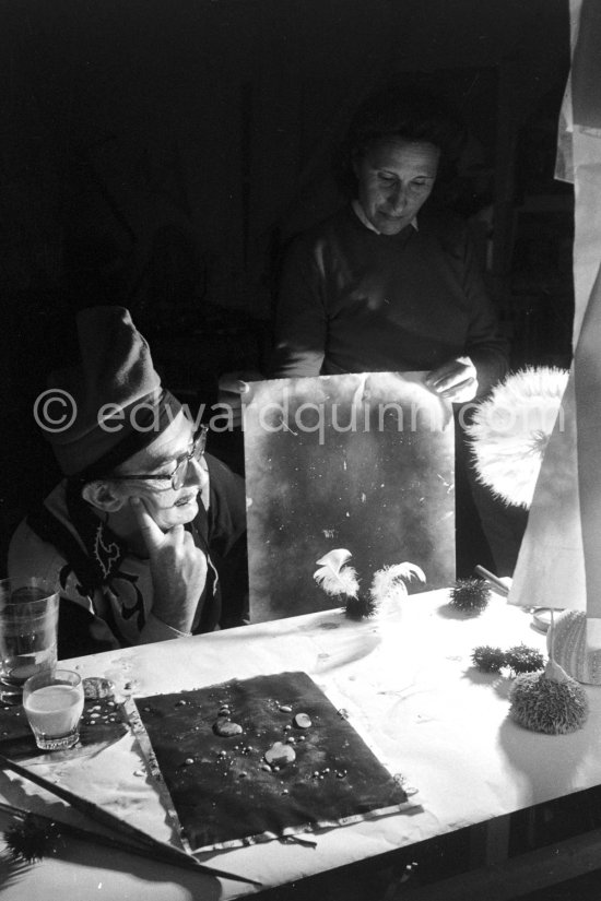 Watched by his wife Gala, Salvador Dalí works on his experiments with the sea urchin holding a swan feather and moving backwards and forewards thus marking the blackened paper. These experiments he is carrying out at his studio in his Spanish home at Portlligat, Cadaqués, on the Costa Brava 1957. - Photo by Edward Quinn