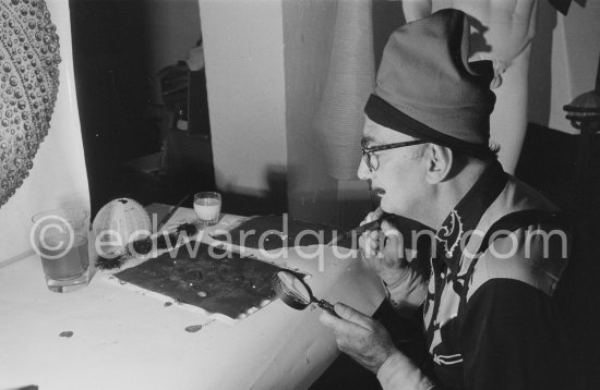 Salvador Dalí demonstrates the origin of the "oursin", a liquid which takes on a particular form. Here he is seen using milk and water. At Salvador Dalí\'s house, Portlligat, Cadaqués 1957. - Photo by Edward Quinn