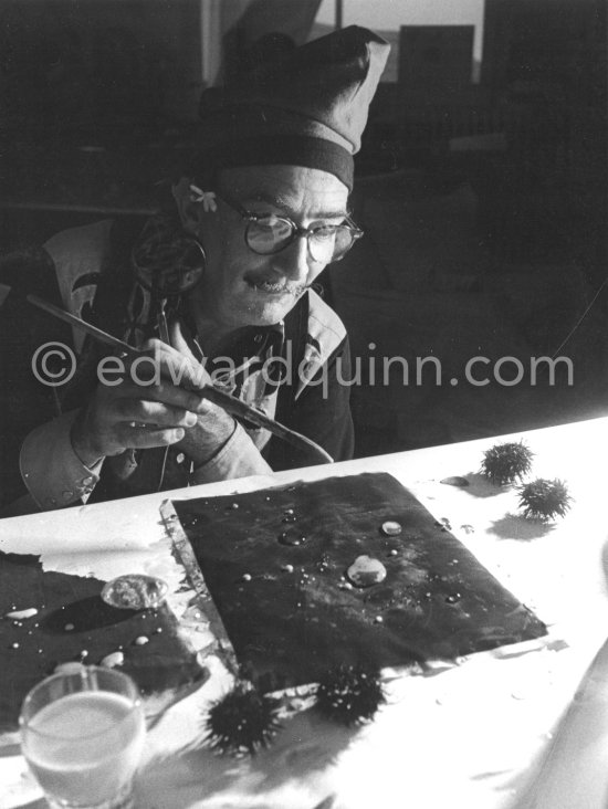 Salvador Dalí demonstrates his view of the origin of the sea urchin, a liquid which takes on a particular form. At Dalí\'s house, Portlligat, Cadaqués 1957. - Photo by Edward Quinn