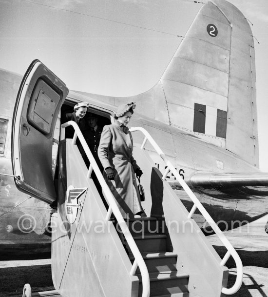 The onlookers saw Princess Elizabeth, later Queen Elizabeth II, very stylishly dressed disembarking from a Viking C2 aircraft, King\'s Flight, during the stop she made at Nice Airport, while on a flight from London to Malta where she was going to meet the Duke of Edinburgh, Prince Philip. She was greeted by local officials. Nice 19.3.1951. - Photo by Edward Quinn