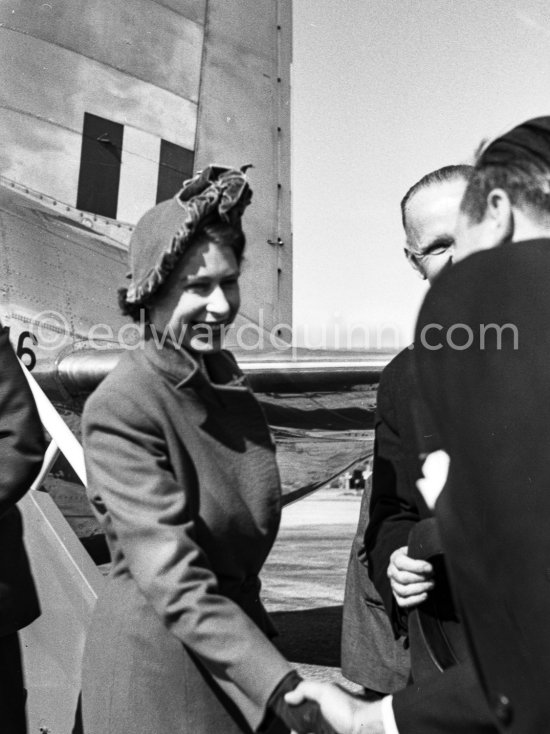 The onlookers saw Princess Elizabeth, later Queen Elizabeth II, very stylishly dressed disembarking from a Viking C2 aircraft, King\'s Flight, during the stop she made at Nice Airport, while on a flight from London to Malta where she was going to meet the Duke of Edinburgh, Prince Philip. She was greeted by local officials. Nice 19.3.1951. - Photo by Edward Quinn