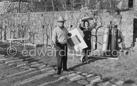 Max Ernst and Dorothea Tanning in the gardens of her house at Seillans 1966. He holds the painting Schmetterling-Steuerzahler (papillon contribuable), for which he has used a piece of wallpaper, a flybat and a note from the income tax officer concerning his income tax return. - Photo by Edward Quinn