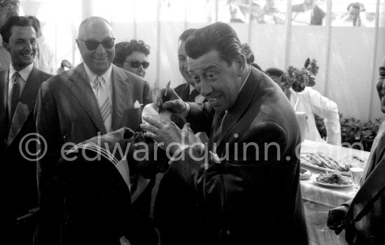 Fernandel signing autograph on the hat of a sailor. Cannes 1956. - Photo by Edward Quinn