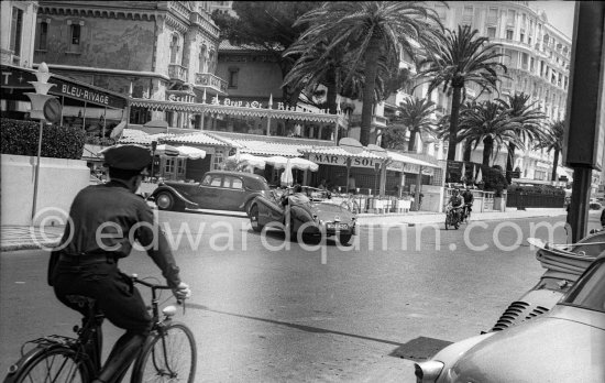 Clark Gable and “fiancée” Suzanne Dadolle, French model, in front of Hotel Bleu Rivage. Cannes 1953. 1951 Jaguar XK120 OTS Battleship grey/red. Car today see https://bit.ly/3kLirWW - Photo by Edward Quinn