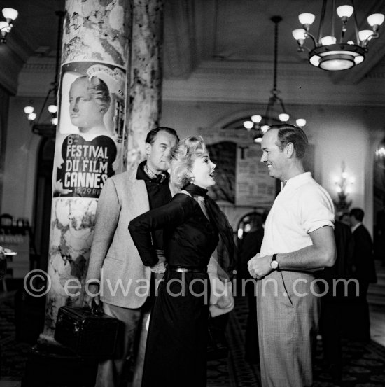 Zsa Zsa Gabor enjoys a conversation with Earl Blackwell of "Celebrity Service". On the left (hidden) Zsa Zsa’s husband Georg Sanders, carrying the bags. Cannes Film Festival 1953. - Photo by Edward Quinn