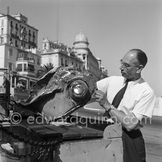 The accident at Sainte-Dévote: parts of a damaged car. Monaco Grand Prix 1952, transformed into a race for sports cars. This was a two day event, the Sunday for the up to 2 litres (Prix de Monte Carlo), the Monday for the bigger engines, (Monaco Grand Prix). 
The Aston engine of Parnell blows up in the Ste-Devote and aligns his car against the straw bales, Stagnoli brakes too hard and does a double spin. Moss, Jaguar C-Type XKC 003 and Manzon find an obstructed road, spin and end up against the poor Aston, then Hume spins and reverses into the pile. Fortunately nobody gets hurt. Moss restarted after the accident, but got a black flag for receiving outside help. - Photo by Edward Quinn