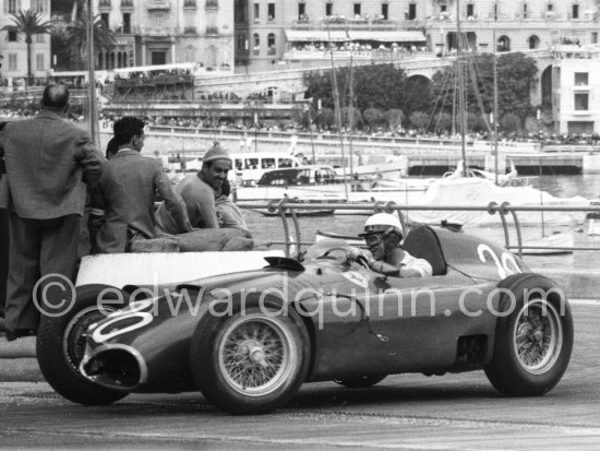 Eugenio Castellotti in Fangio\'s (20) Ferrari-Lancia D50. Trintignant with pointed cap watches- Monaco Grand Prix 1956. - Photo by Edward Quinn