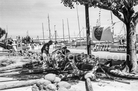 Stirling Moss and Mike Hawthorn inspecting the wreck of Moss' (18) Vanwall VW3/4 in the barriers. Monaco Grand Prix 1957. - Photo by Edward Quinn