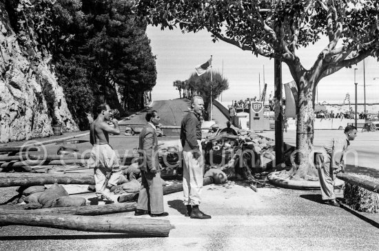 Stirling Moss and Mike Hawthorn with the wreck of Moss\' (18) Vanwall VW3/4 in the barriers. Monaco Grand Prix 1957. - Photo by Edward Quinn