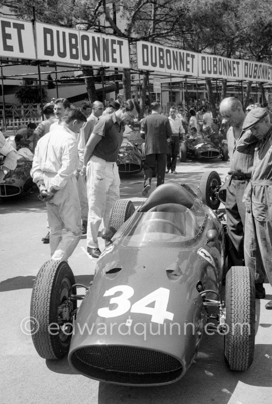 Richie Ginther (with hat), (34) rear engined "motore posteriore" experimental Ferrari 246/60/MP. On the left Graham Hill, Bruce McLaren and Joakim Bonnier. Monaco Grand Prix 1960. - Photo by Edward Quinn