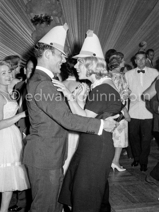 Stirling Moss, winner of the Grand Prix, gets into the party spirit with paper hat and cha-cha as he dances with Swedish model Helga Mayerhoffer. Gala of Monaco Grand Prix 1960. - Photo by Edward Quinn