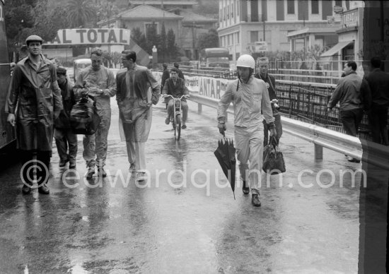 Heavy rainstorm marred practice. Phil Hill carries with him an umbrella. On the left Dan Gurney. Monaco Grand Prix 1962. - Photo by Edward Quinn