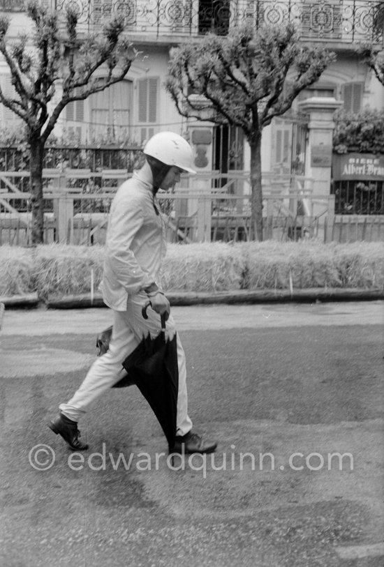 Heavy rainstorm marred practice. Phil Hill carries with him an umbrella. Monaco Grand Prix 1962. - Photo by Edward Quinn